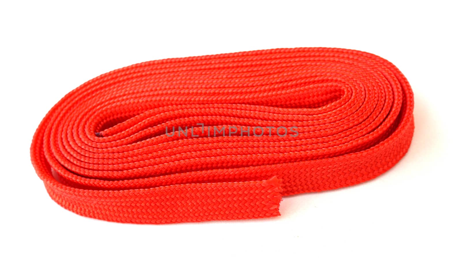 Red rope on white background. Fabric rope in red color folded in a coil.