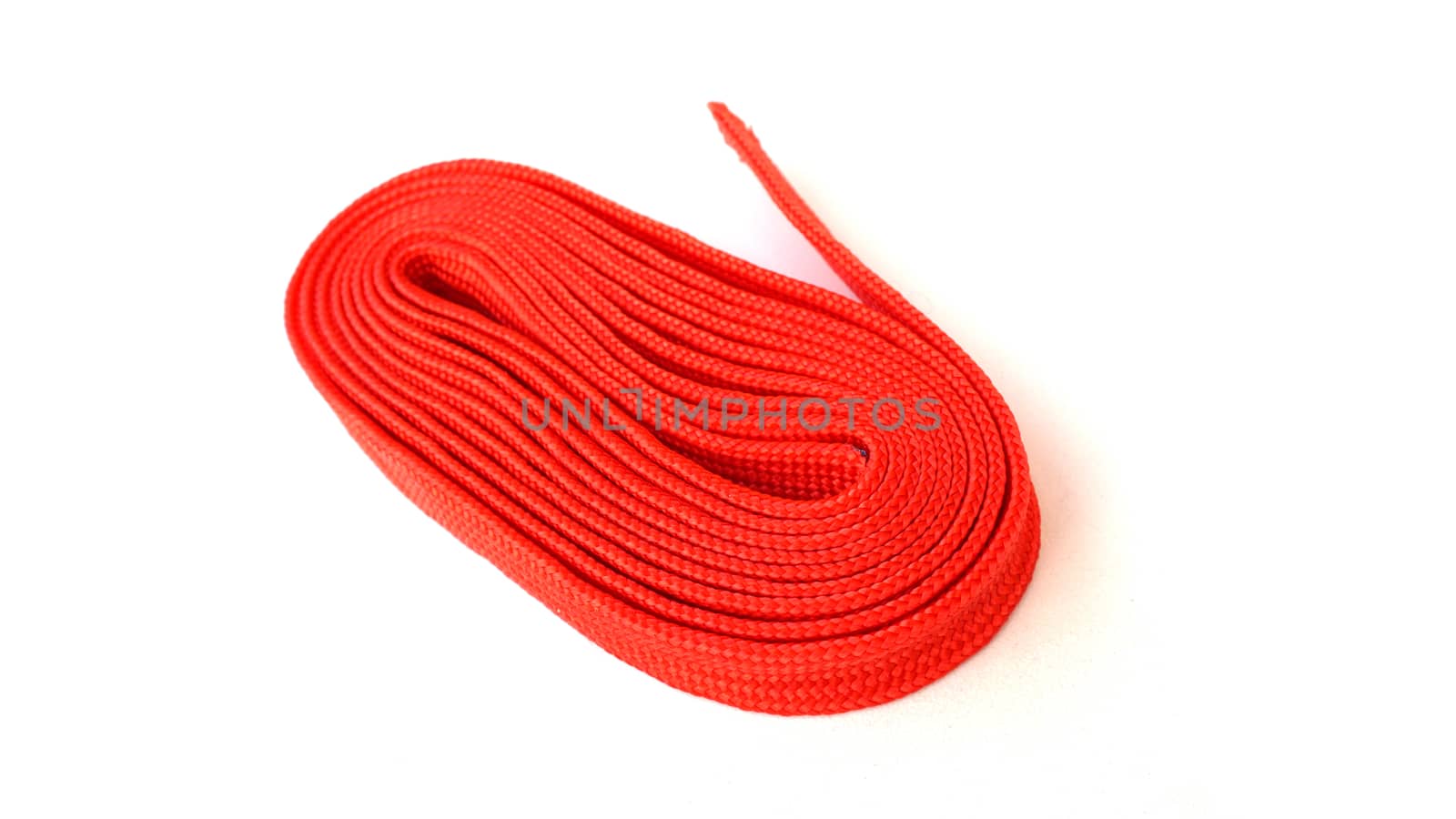 Red rope on white background. Fabric rope in red color folded in a coil.