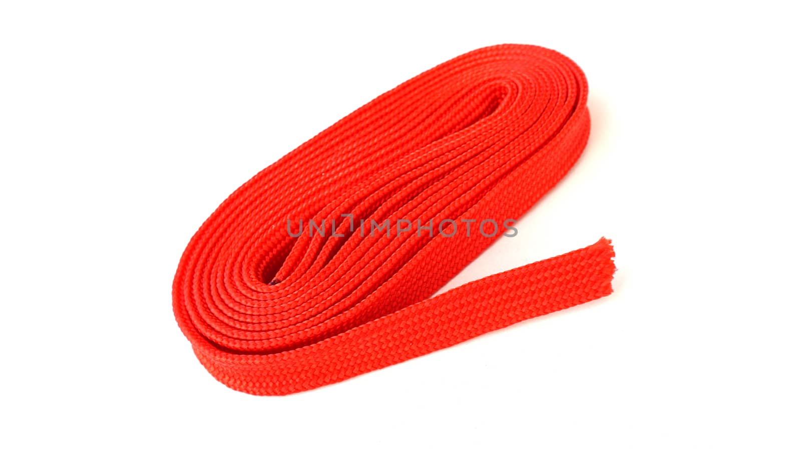 Red rope on white background. Fabric rope in red color folded in a coil.