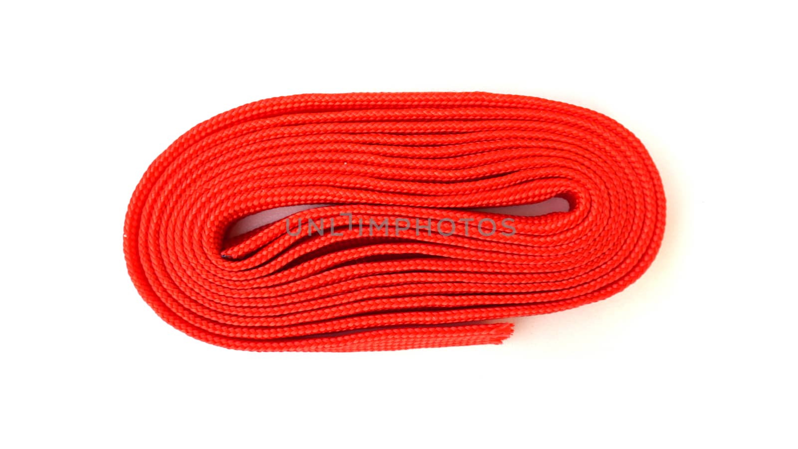 Red rope on white background. Fabric rope in red color folded in a coil.