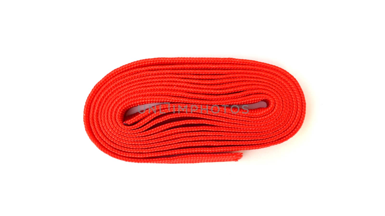 Red rope on white background. Fabric rope in red color folded in a coil.