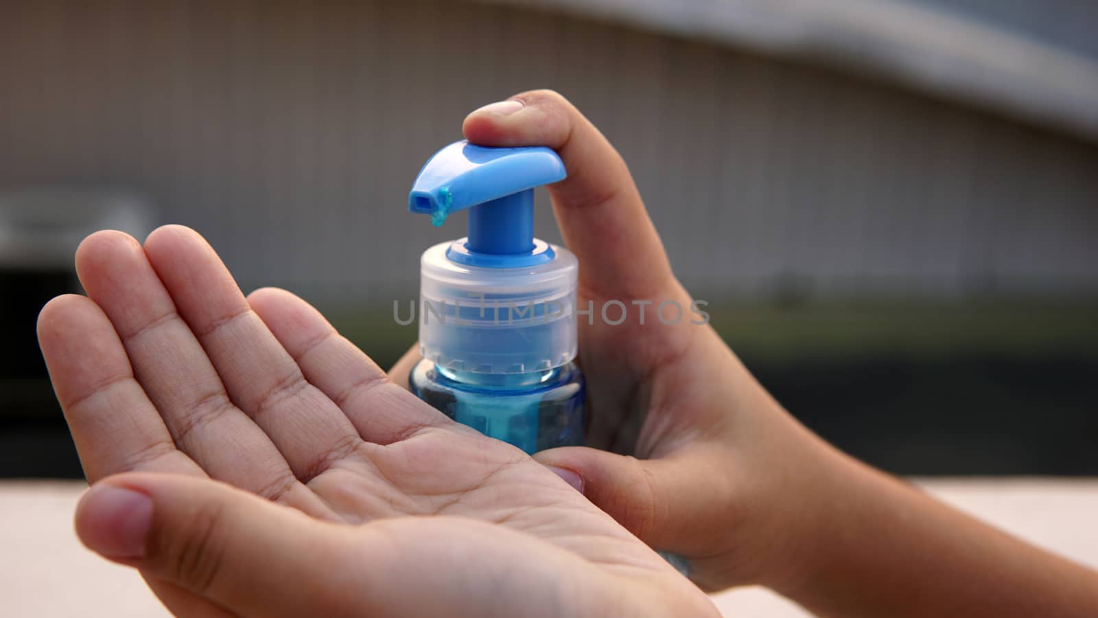 Kid washing hands with anti disinfectant alcohol based gel to protect from corona virus.