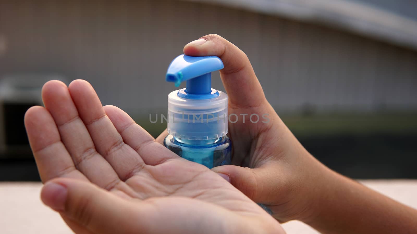 Kid washing hands with anti disinfectant alcohol based gel to protect from corona virus.