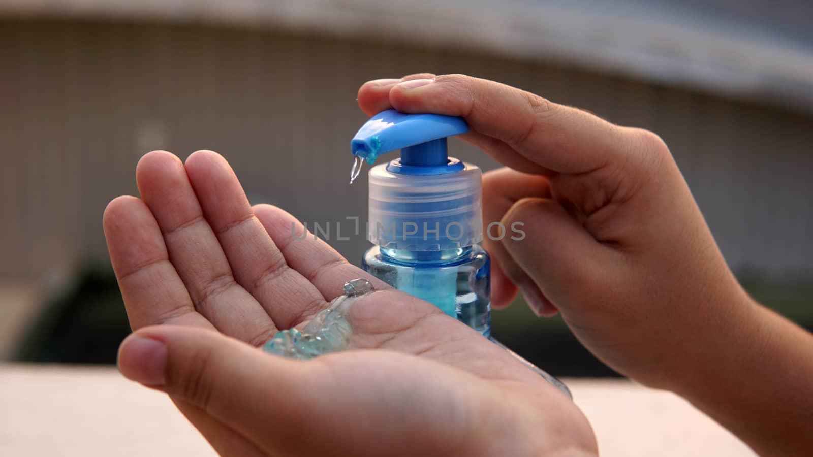 Kid washing hands with anti disinfectant alcohol based gel to protect from corona virus.