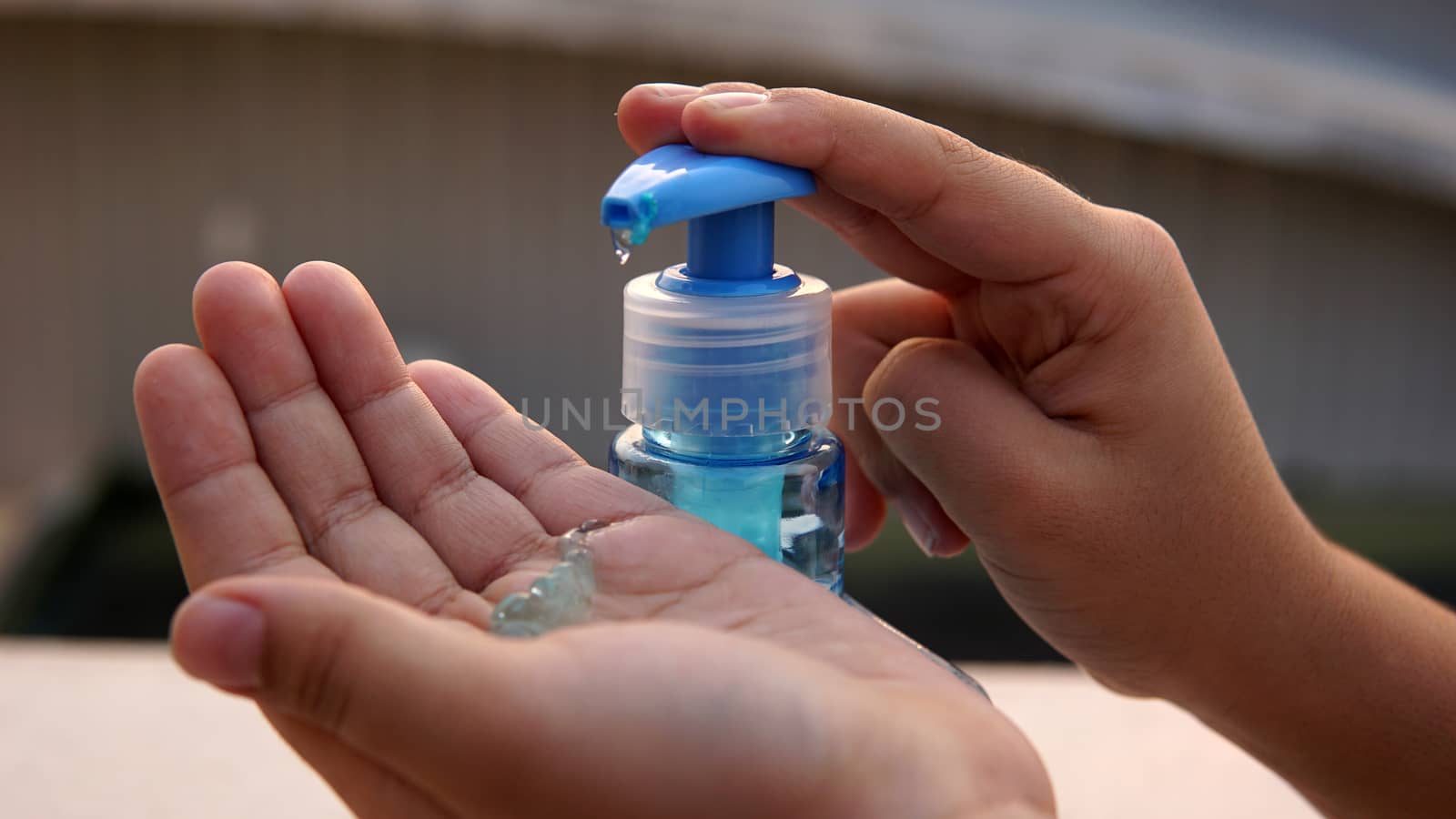 Kid washing hands with anti disinfectant alcohol based gel to protect from corona virus.