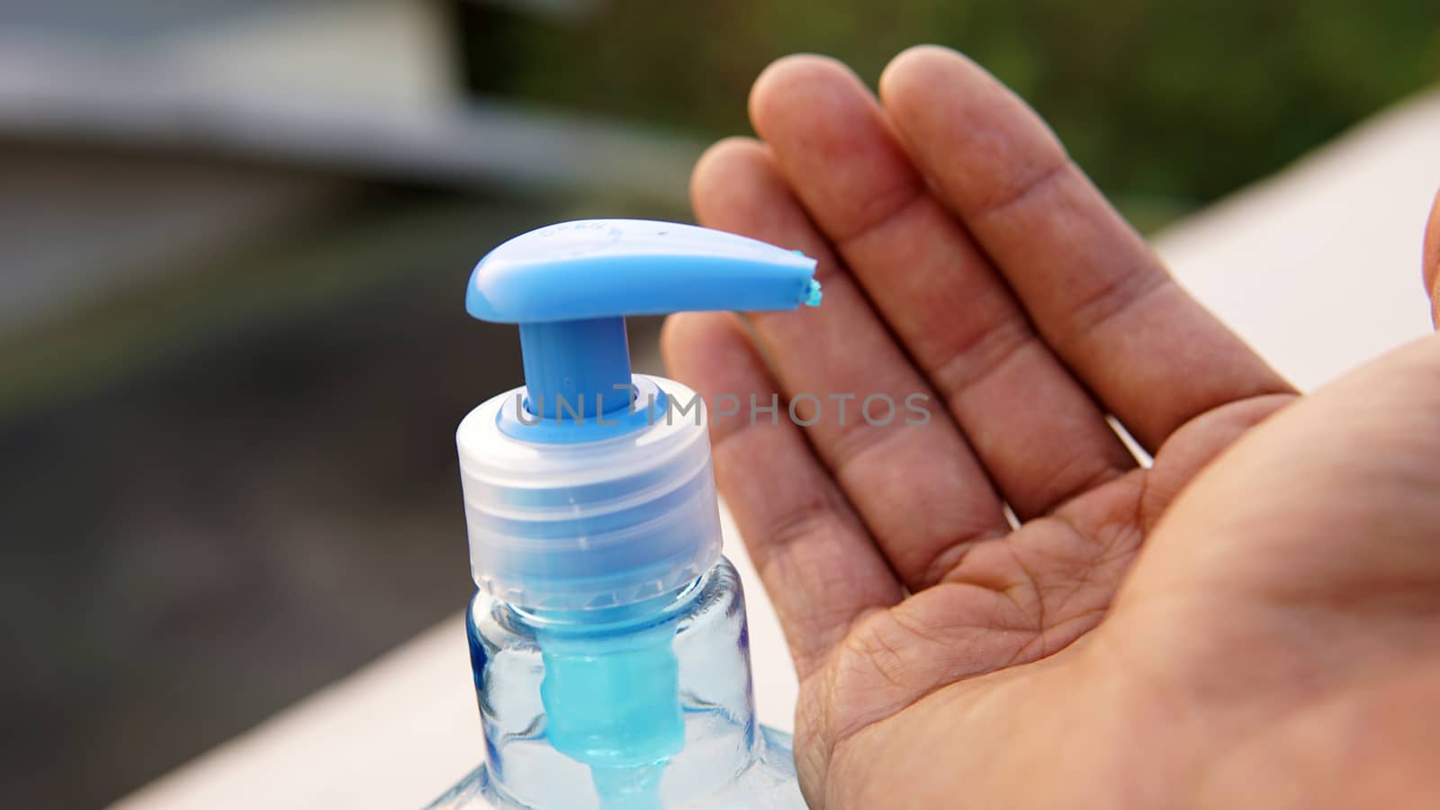 Washing hands with alcohol based gel from a hand pump bottle to protect against corona virus or Covid-19.