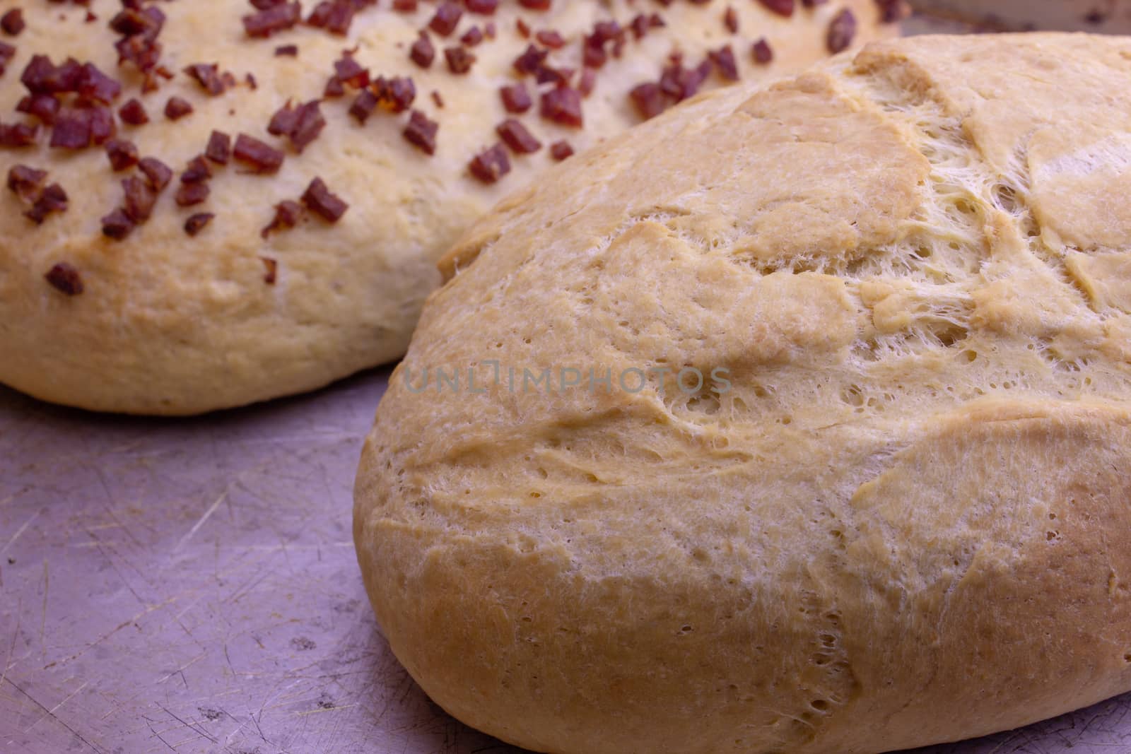 Fresh home baked breads, make out of wheat, one simple and one with pepperoni on top