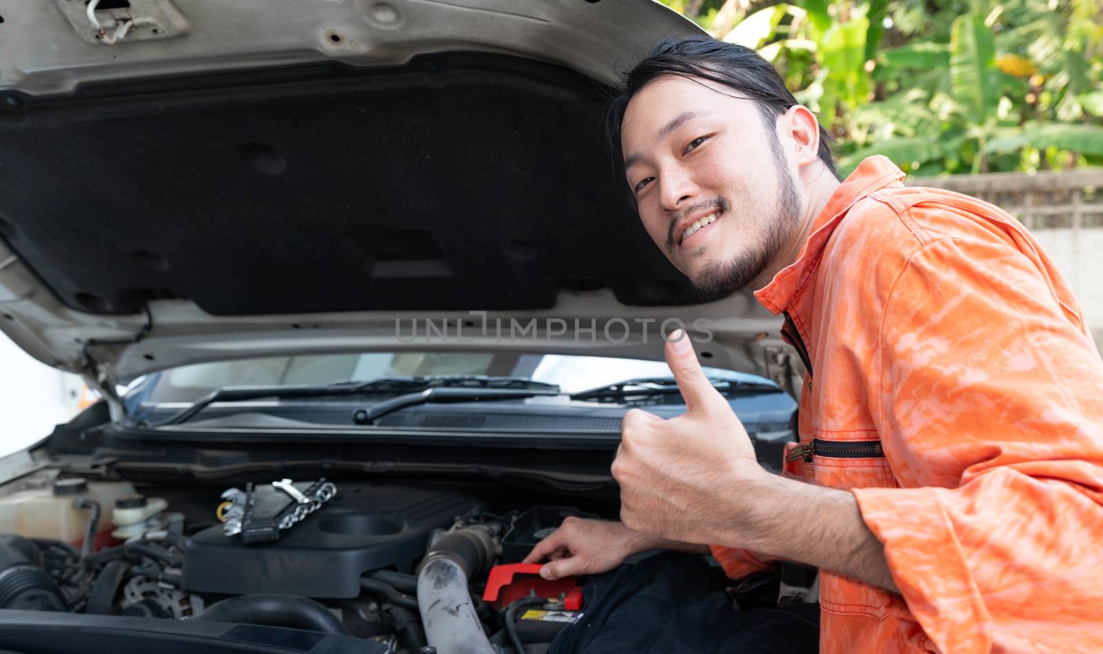 The mechanic opened the car bonnet and discovered an abnormality preventing the car to start. by chadchai_k