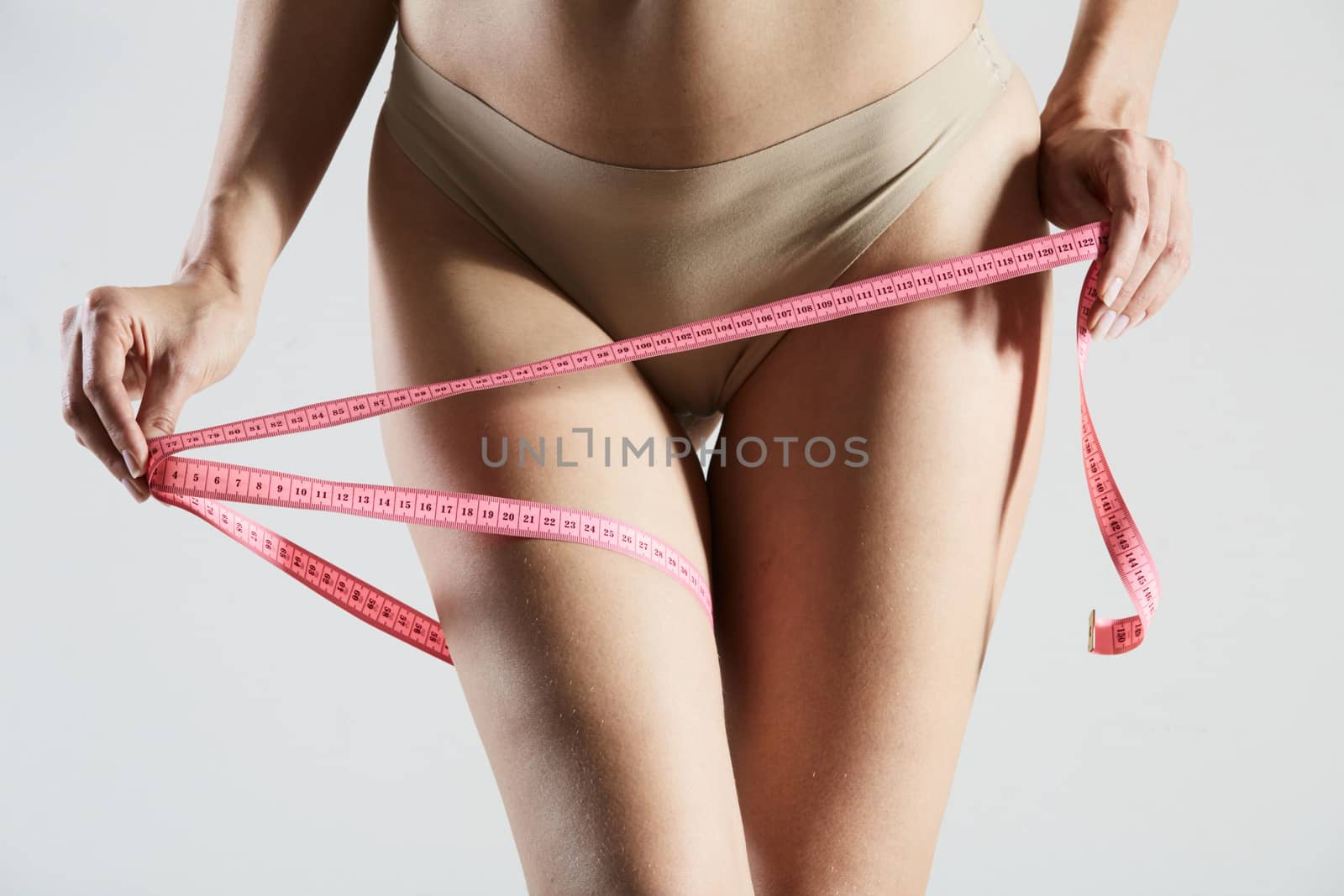 woman measuring perfect shape of beautiful thigh healthy lifestyles concept. No retouch.