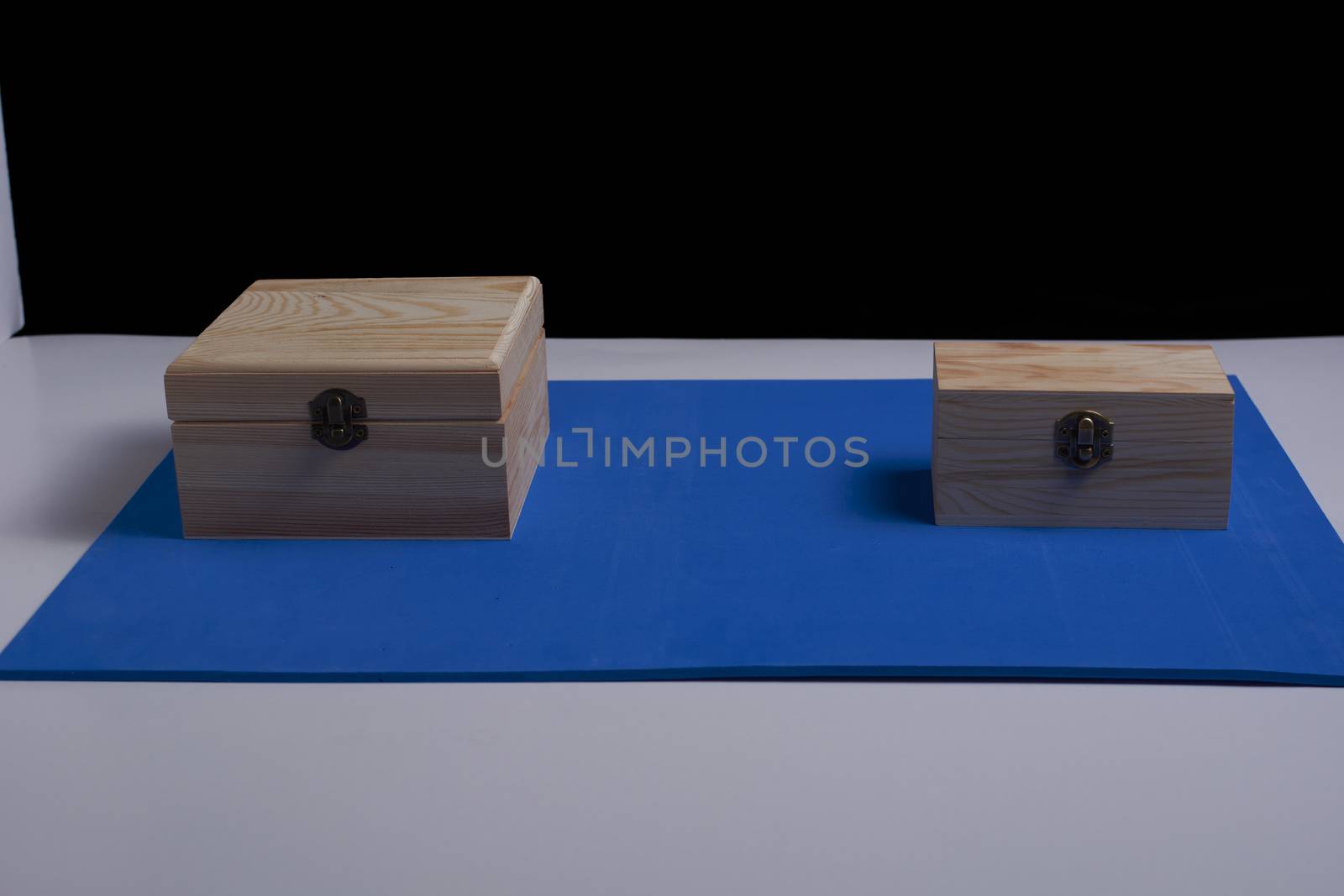 Wooden boxes on black background and blue mat. by raul_ruiz