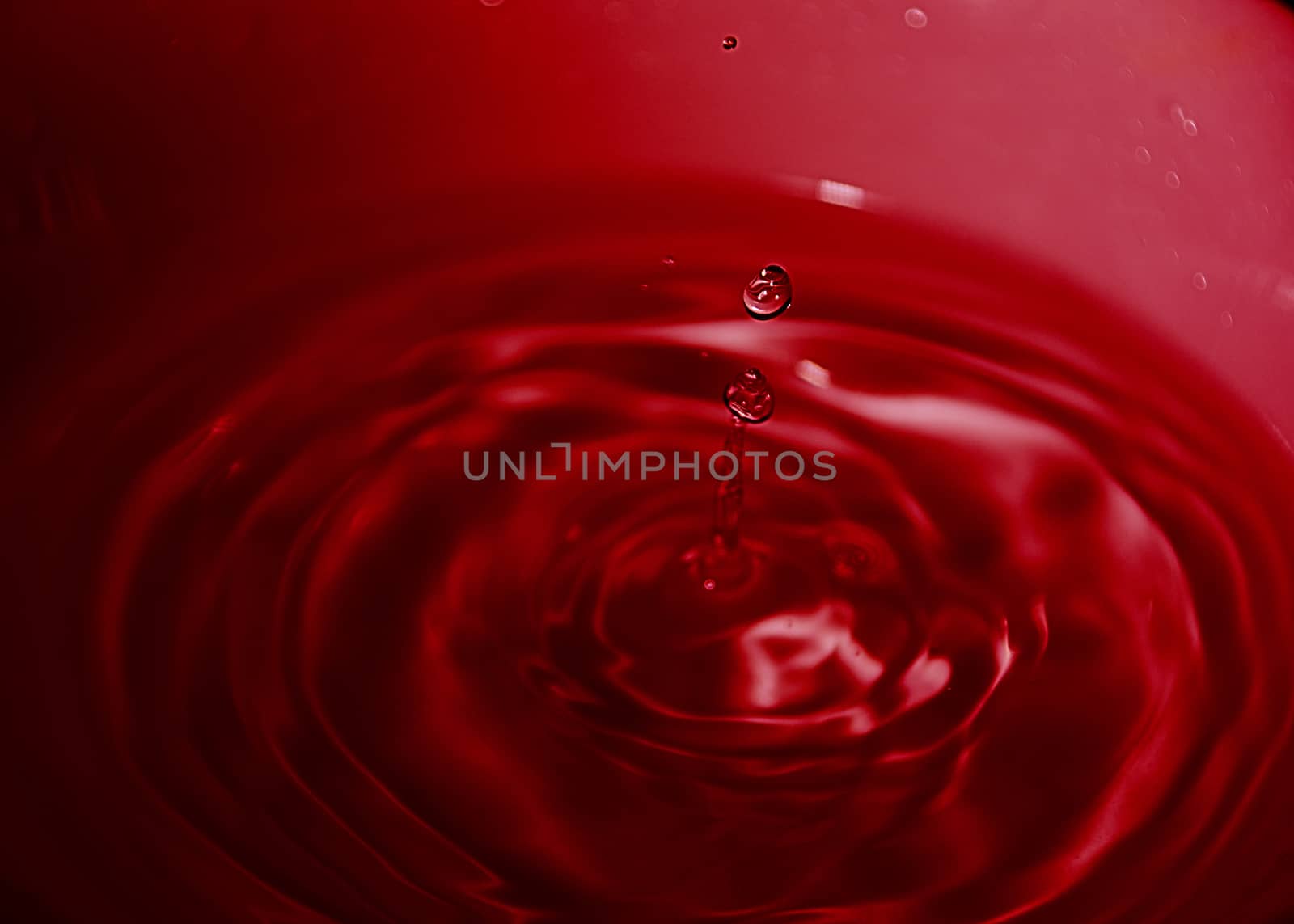 Drop of water on white bowl, red tones, bluish, waves,