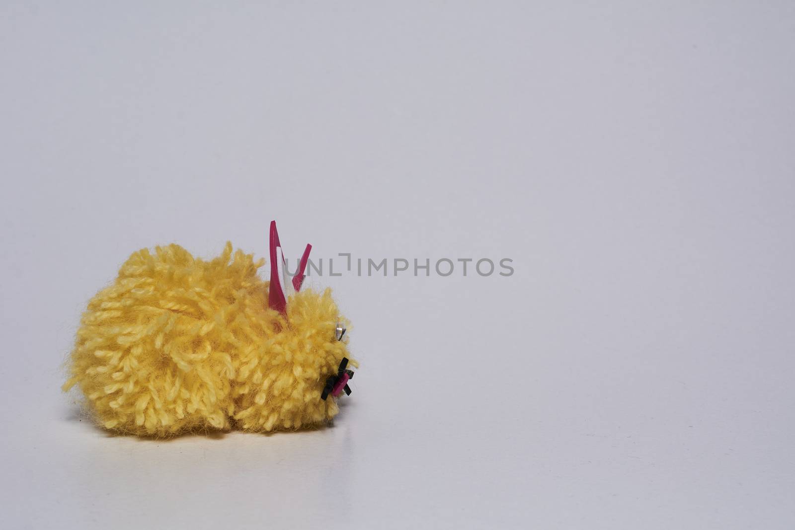 Yellow wool bunny with white background.Crafts at home
