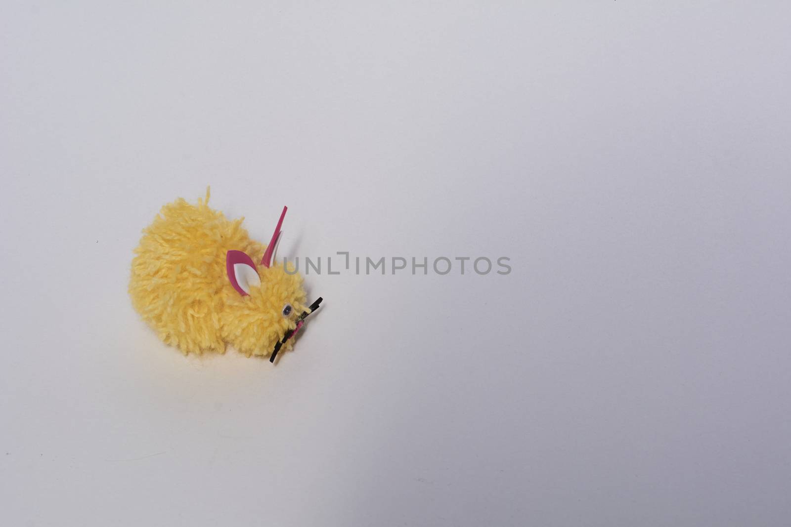 Yellow wool bunny with white background.Crafts at home