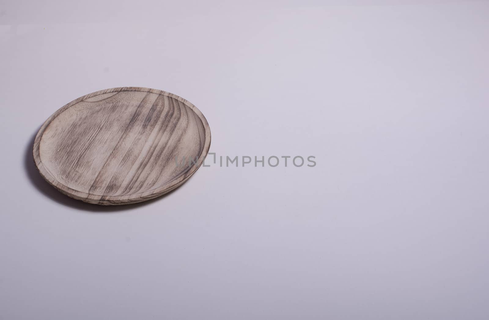 Old wooden plate on white background. Colors of nature