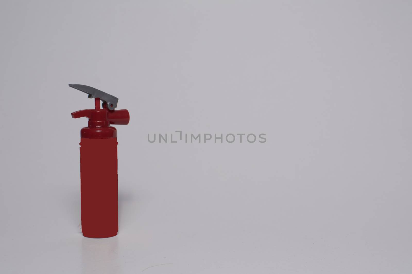 Red toy fire extinguisher on white background by raul_ruiz