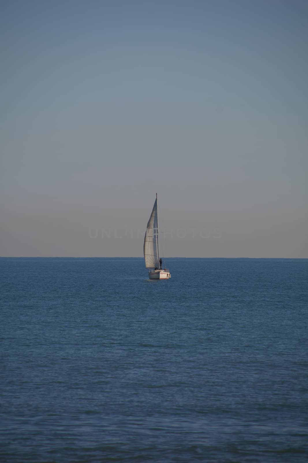 Sailboat in the blue symmetrical calm mediterranean