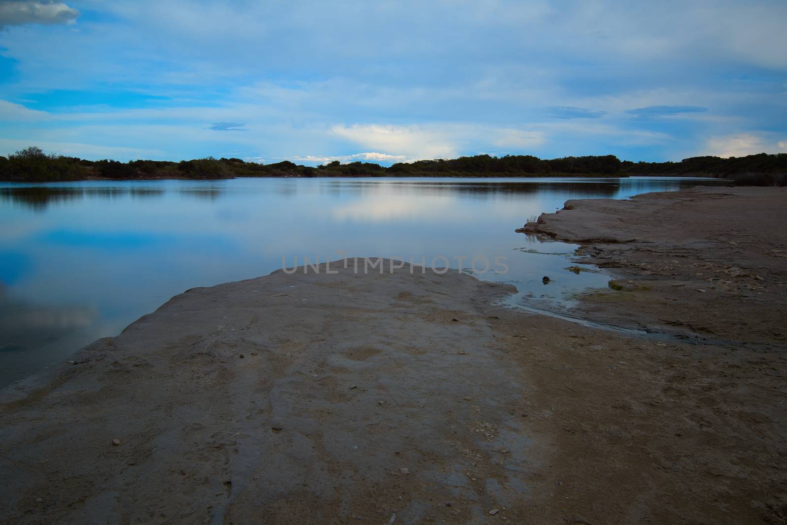 Dark clouds in sunset over the lake. Sunset reflections