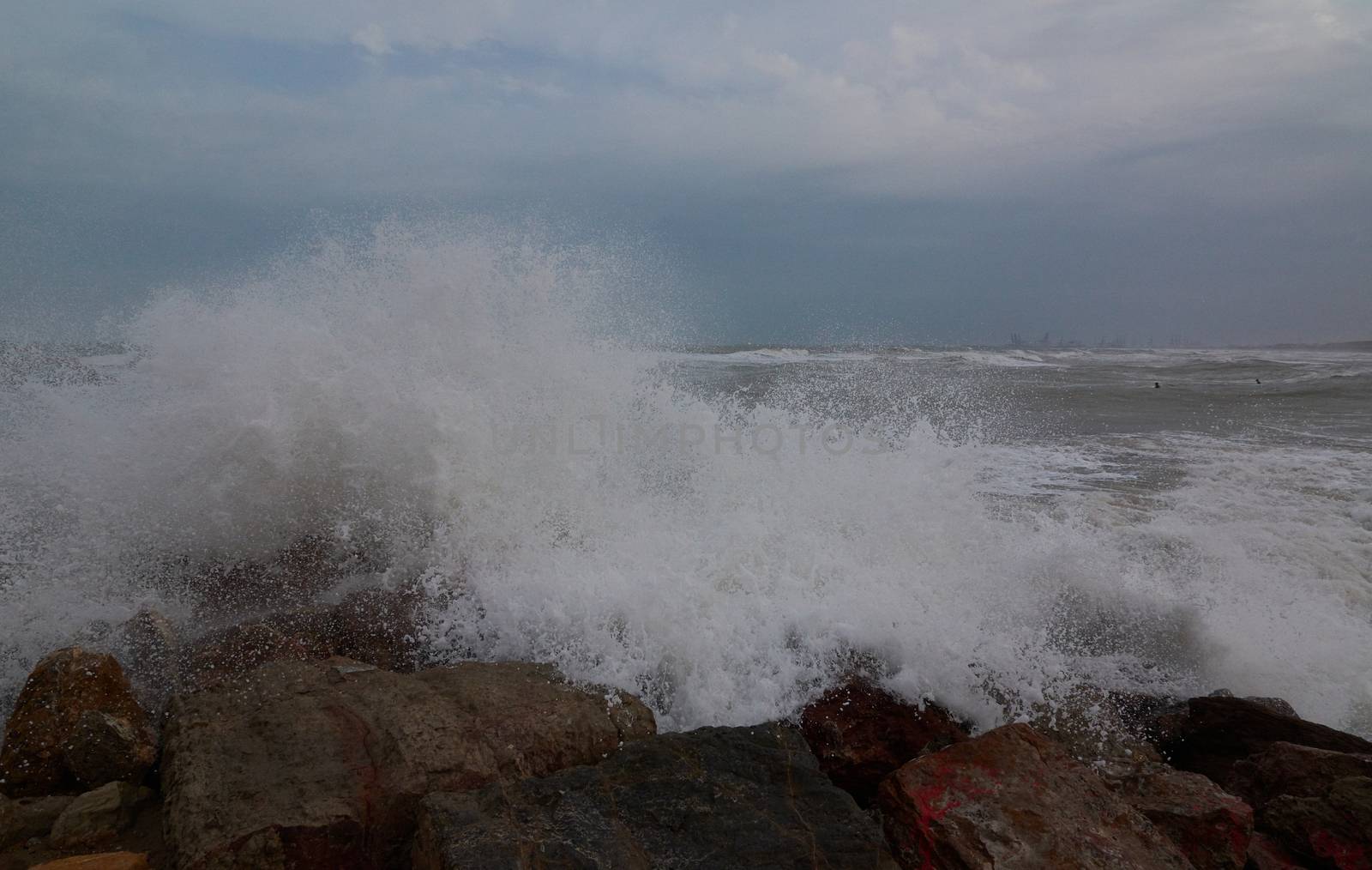 The breaking of the waves on the beach. Storm colors