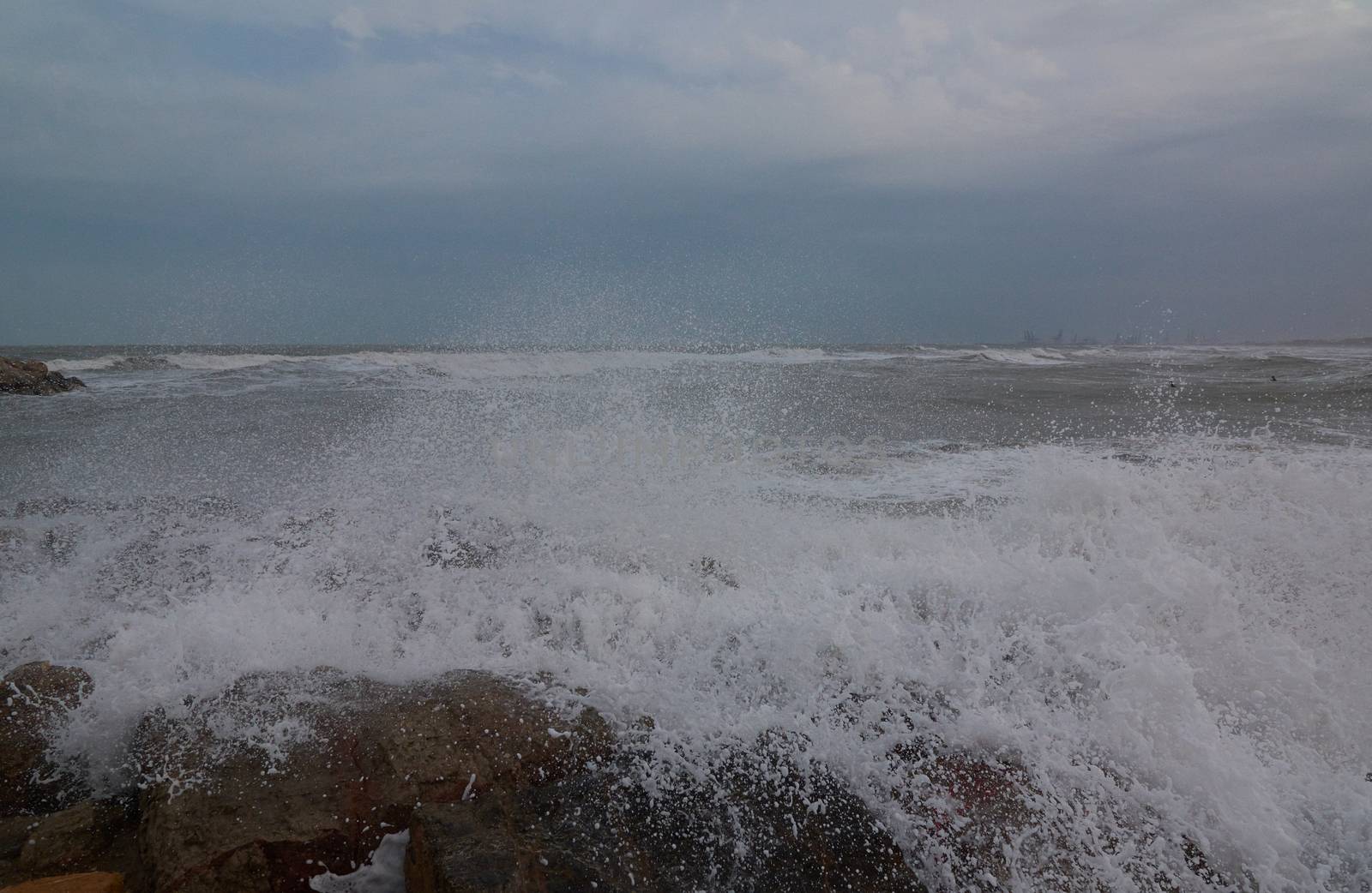 The breaking of the waves on the beach. Storm colors