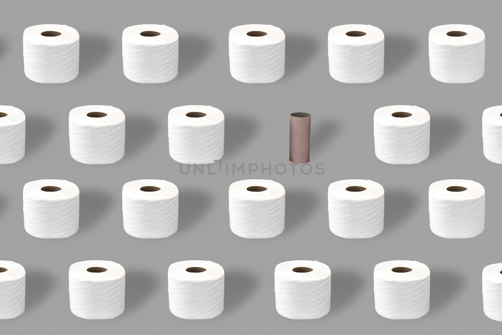 Toilet paper rolls with and empty roll, toilet roll holder on a grey background