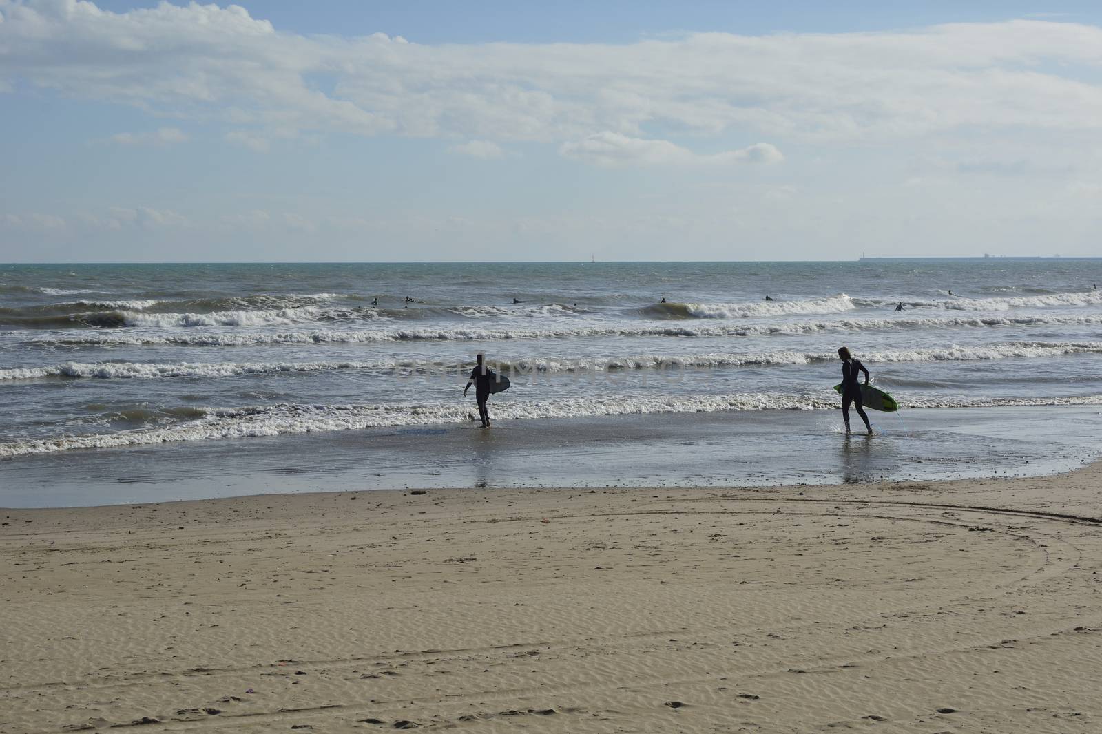 Group of surfers on the beach on a summer day by raul_ruiz