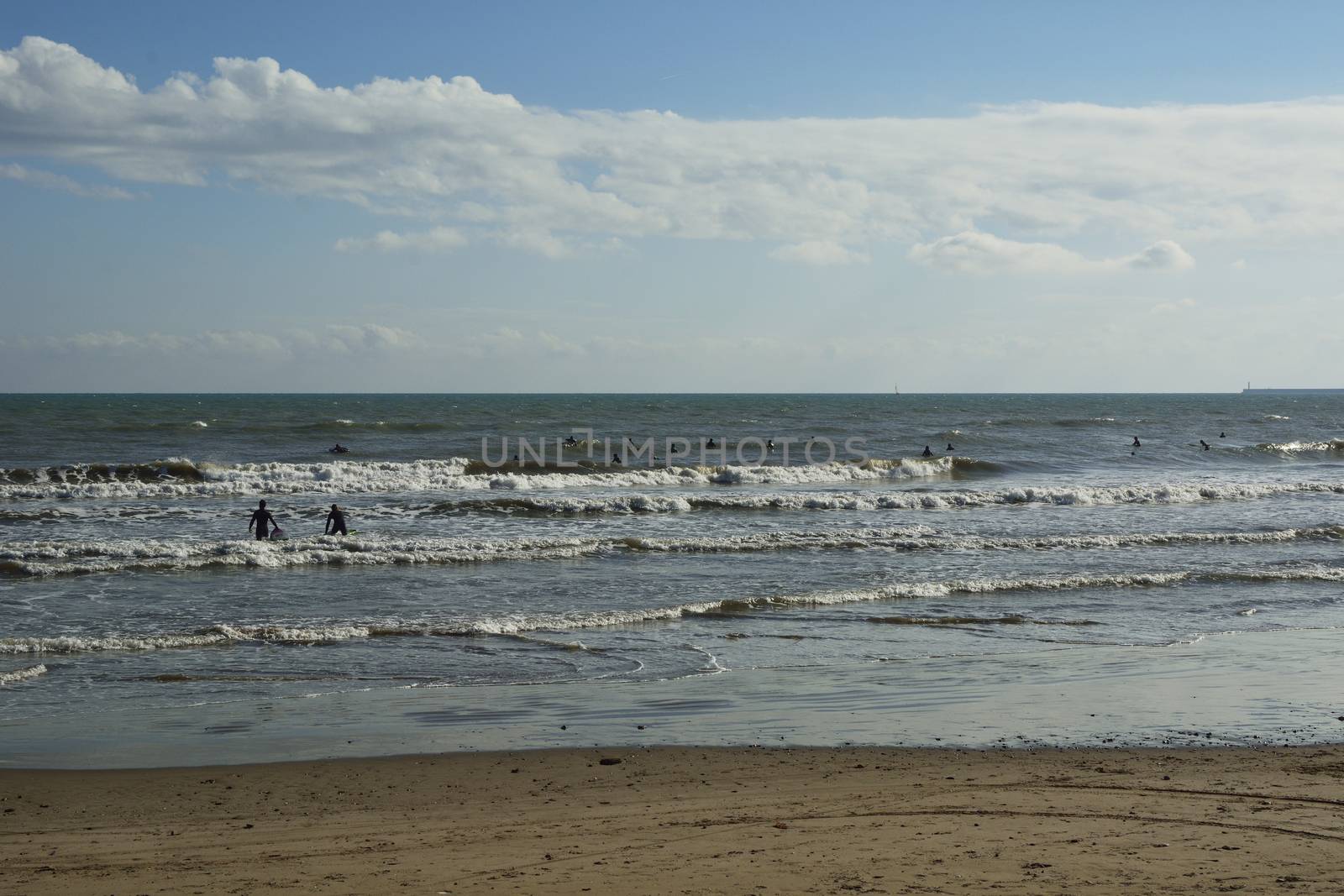 Group of surfers on the beach on a summer day. by raul_ruiz