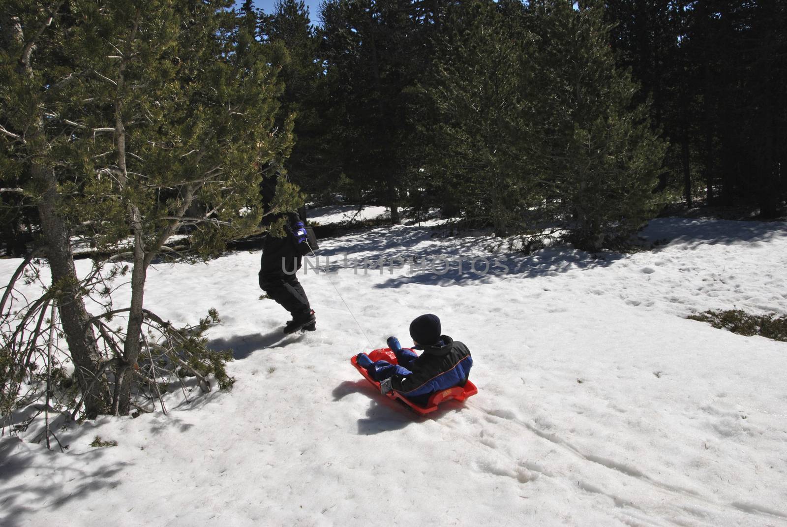 Mother and son playing with a sled, Snowy landscape