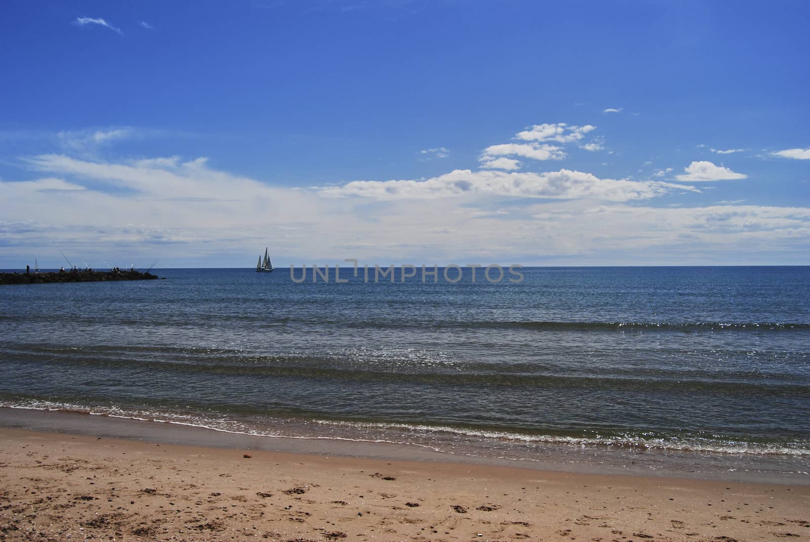 Sailboat sailing through the sea on a bright and calm day. Colors of nature