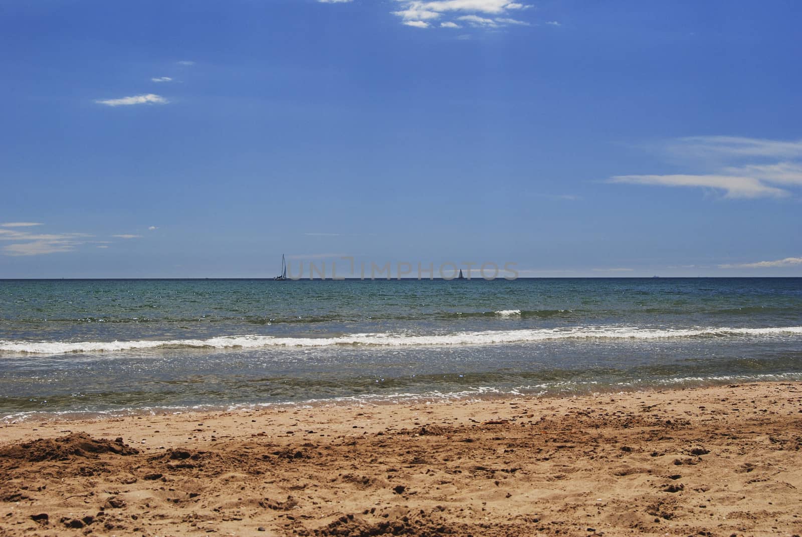 Sailboat sailing through the sea on a bright day. by raul_ruiz