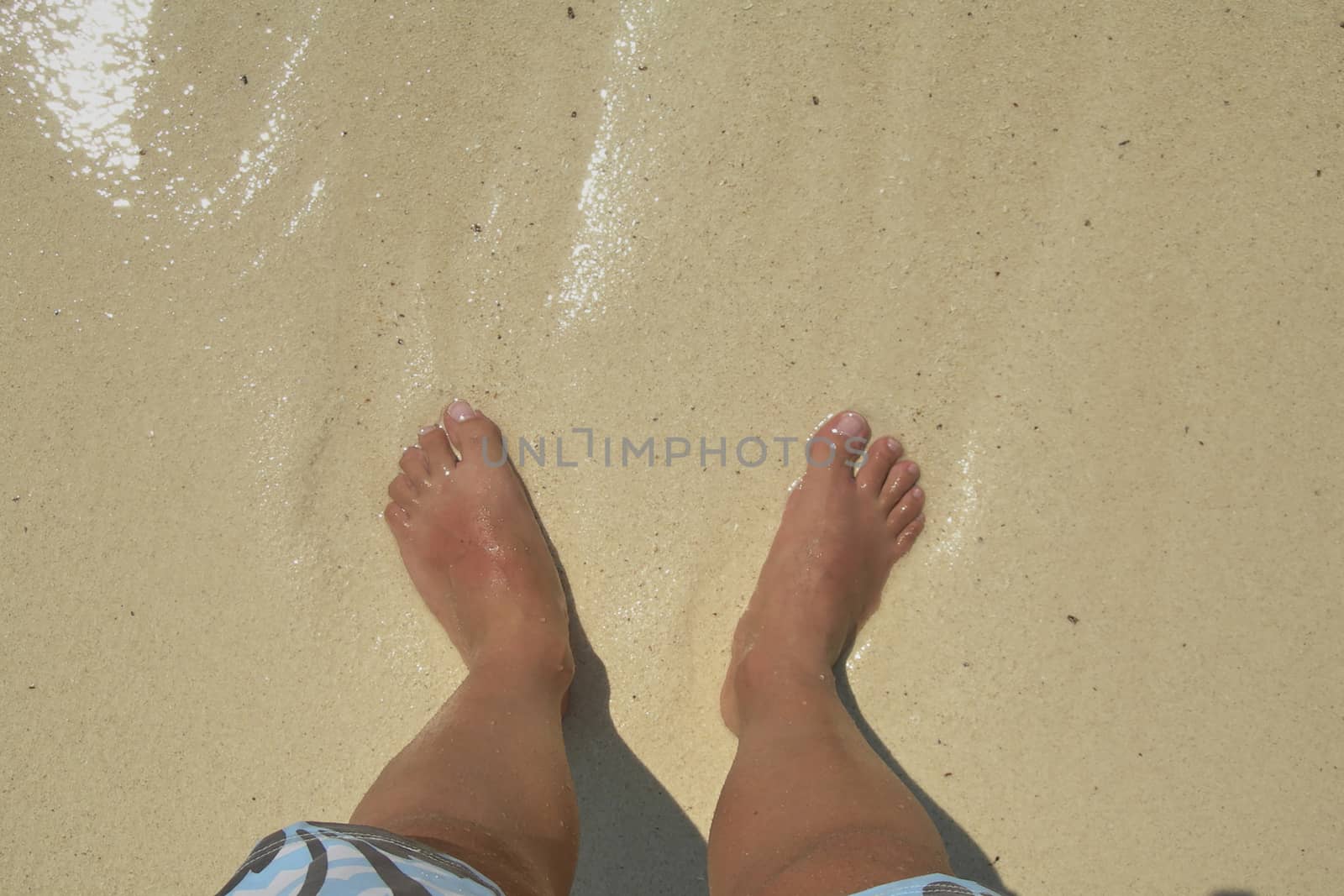 Bare feet in the water on a caribbean beach by raul_ruiz