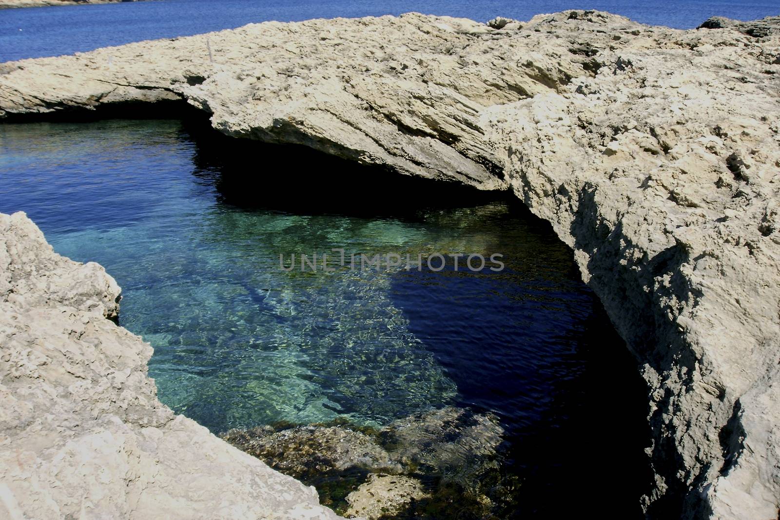 Deserted beach with turquoise waters, bright day, Mountains in the background and bright blue day