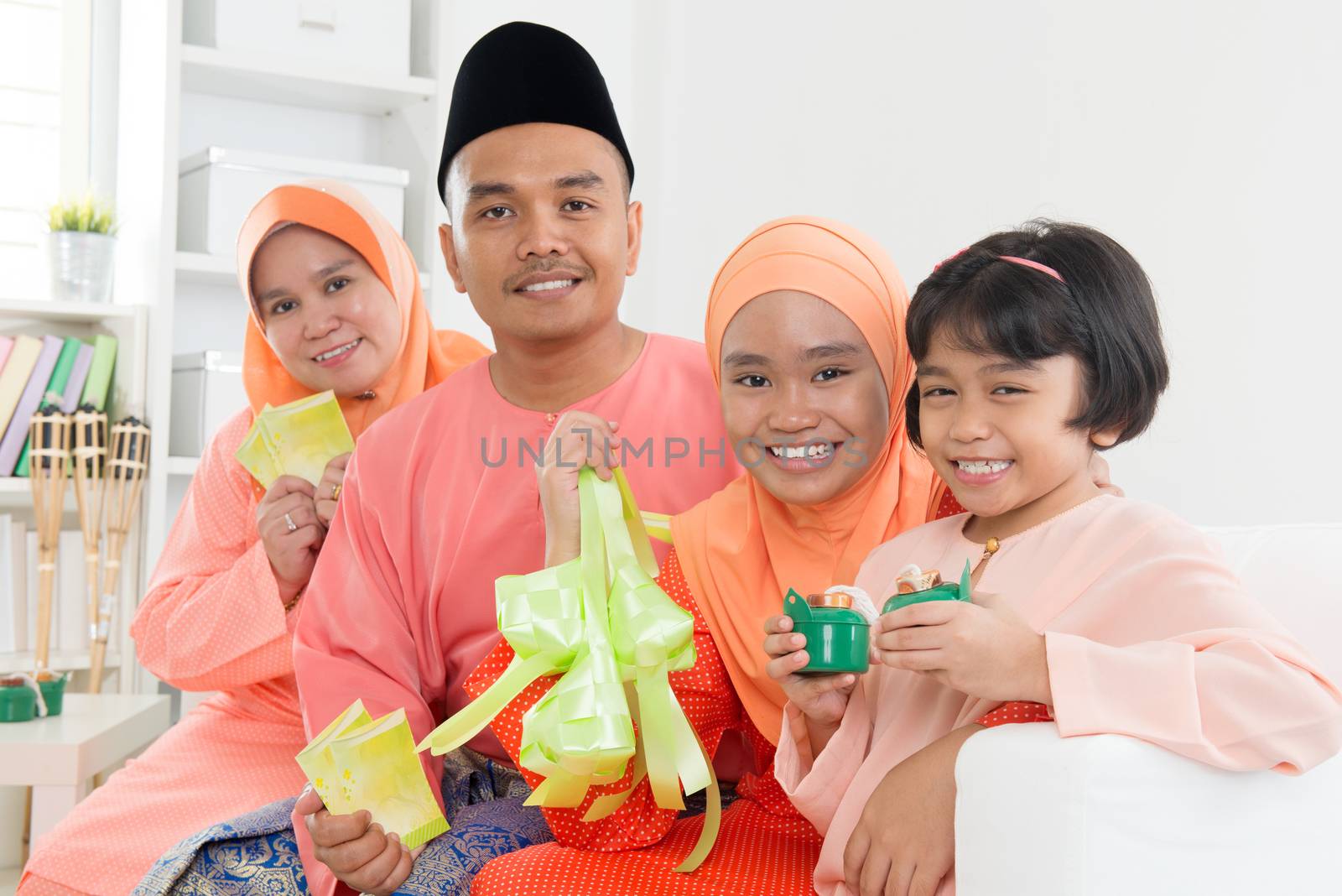 Happy Malay family portrait in traditional clothing during Hari Raya. Malaysian family lifestyle at home.