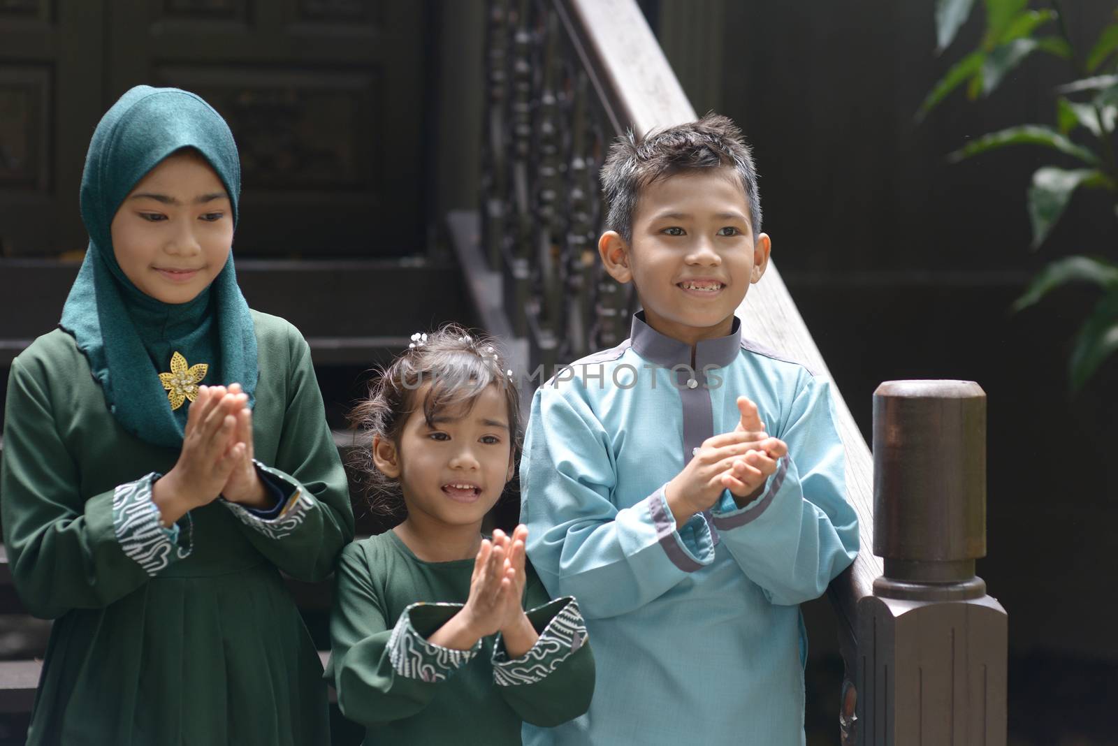 Muslim children clapping hands, Hari Raya Eid Al-Fitr concept. 