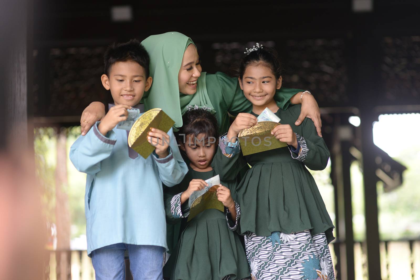 Muslim family, children received money packet as blessing, Hari Raya Eid Al-Fitr concept. 