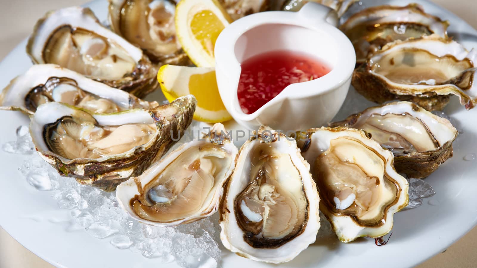 Opened fresh oysters with lemon on dish. Shallow dof.