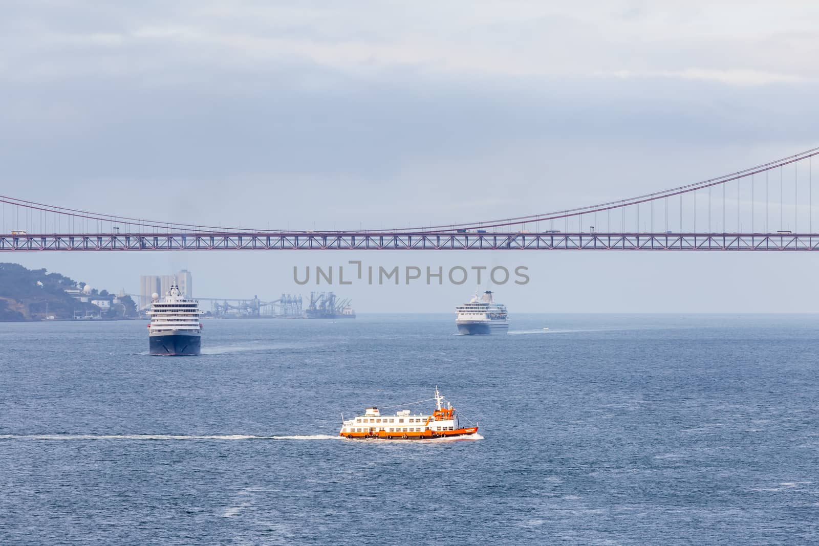 Ships and boats traverse the River Tagus beside the port of Lisbon in Portugal.