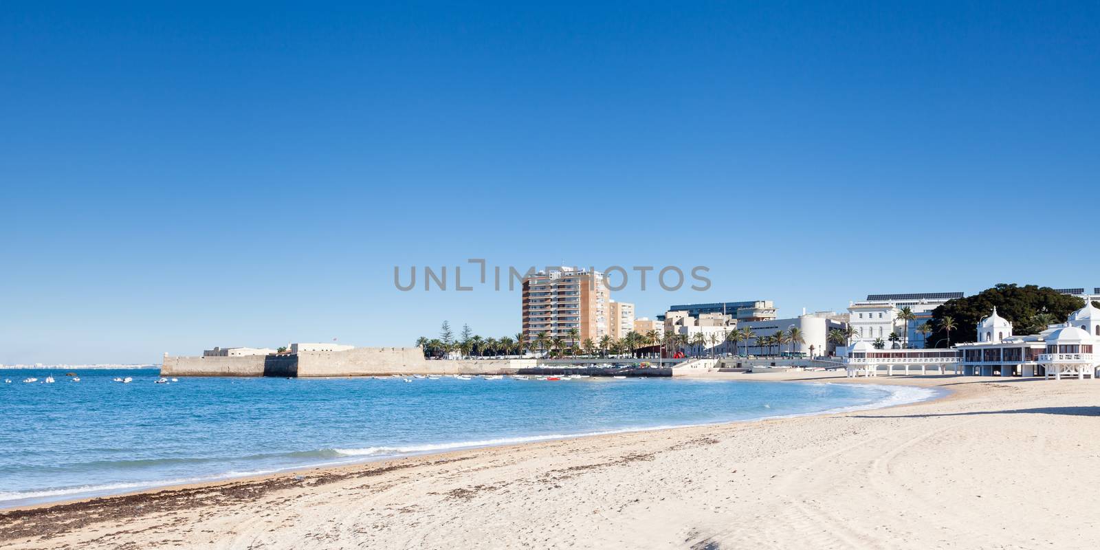 The view across La Caleta beach towards Castillo de San Catalina in Cadiz, Spain.