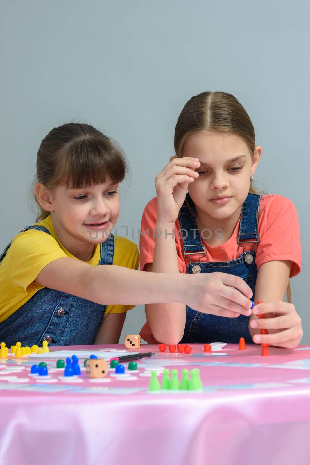 Two girls enthusiastically play a board game