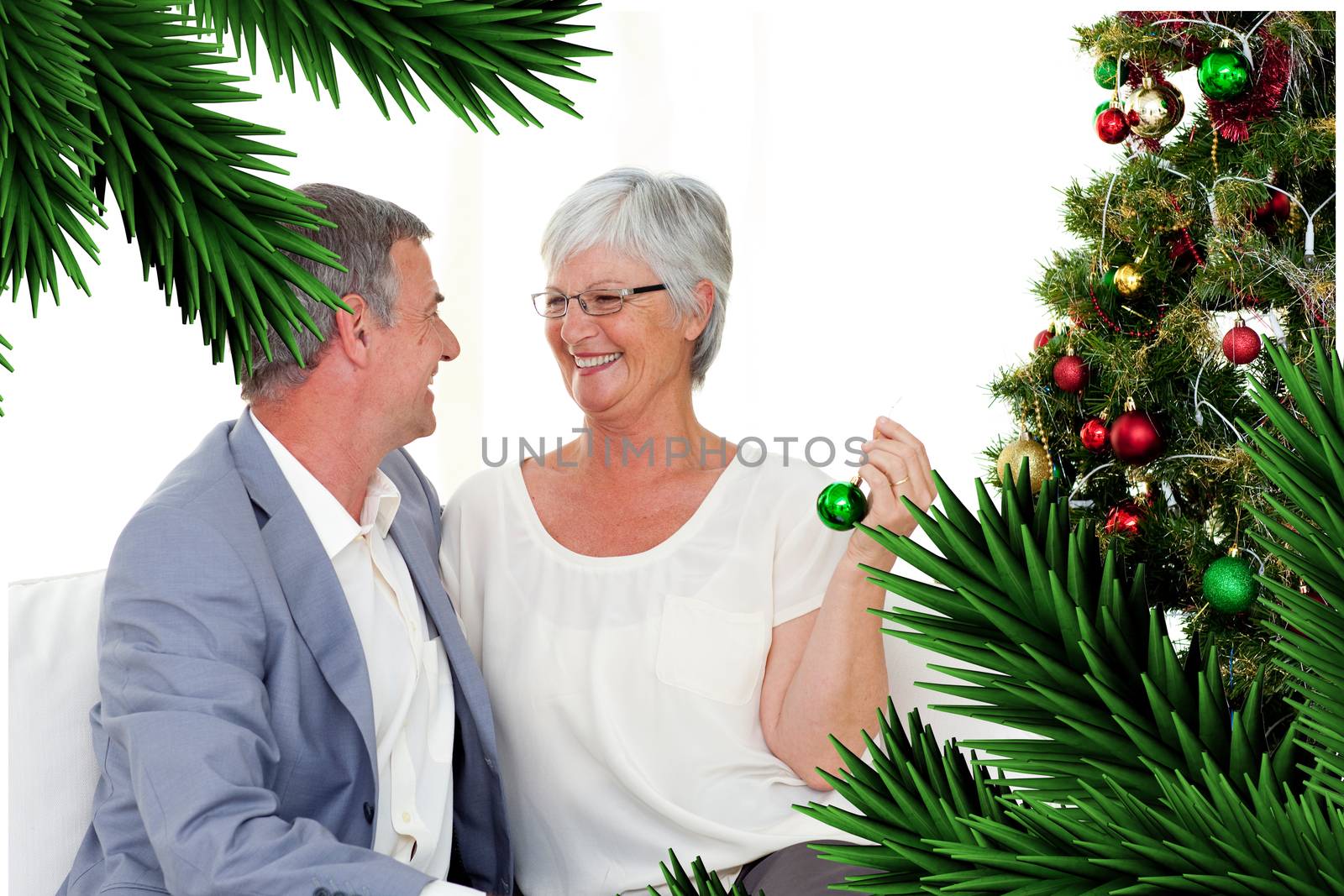 Mature couple sitting on sofa with a christmas tree by Wavebreakmedia