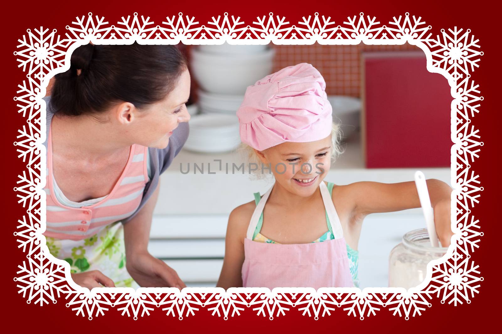 Cheerful mother and her daughter baking in a kitchen against snowflake frame