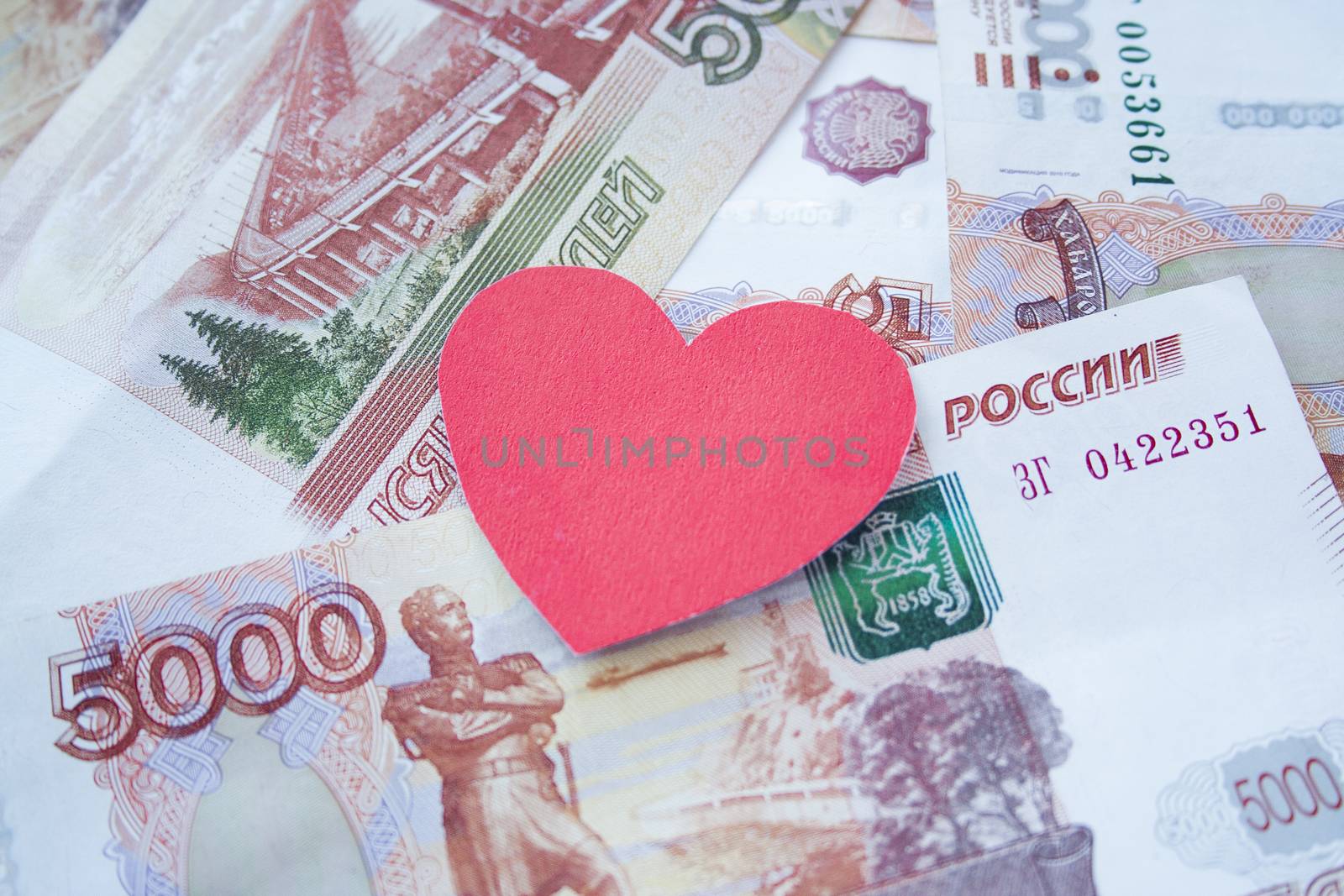 Mortgage, insurance, buying and rent, real estate business concept. Love and money, valentine. Small paper heart shape on money rouble banknotes background side view