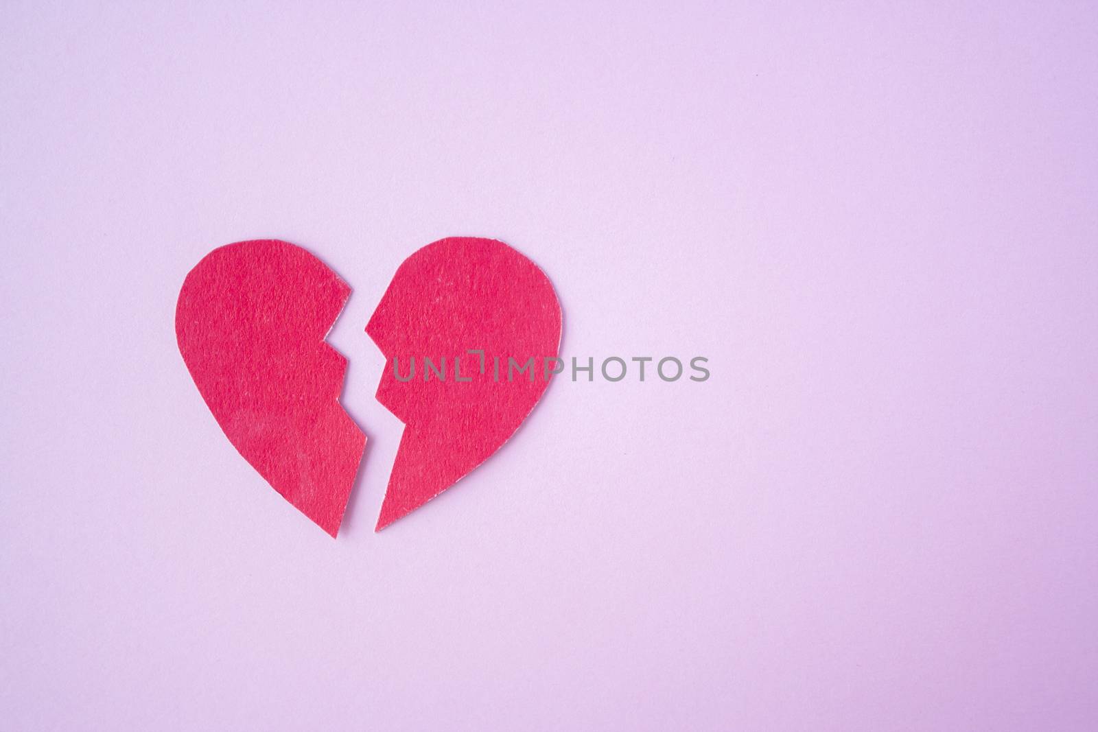 Red paper broken heart on bright background. Divorce, parting, therapy, love, psychologist, family ruined concept