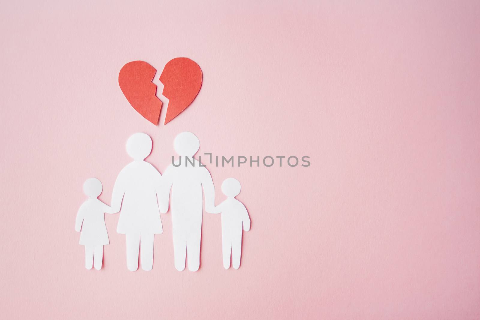 paper family cut out on bright pink background with broken heart above, family home, foster care, family mental health, divorce and family crisis concept