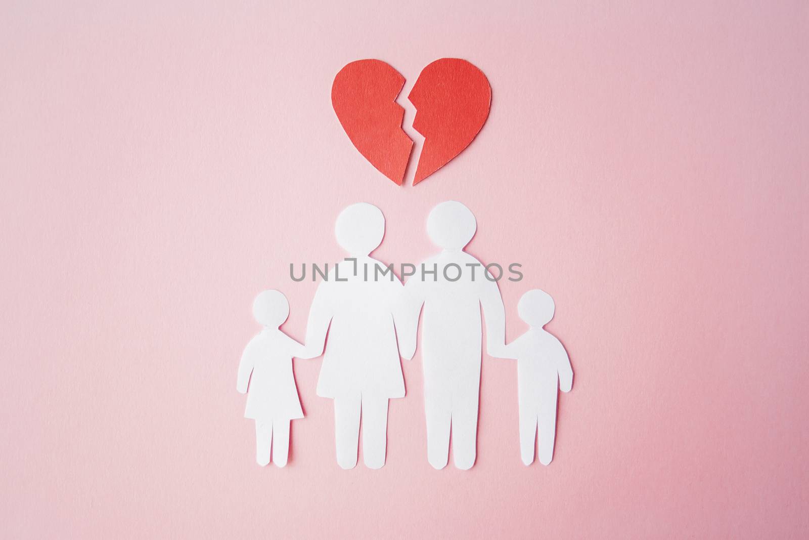 paper family cut out on bright pink background with broken heart above, family home, foster care, family mental health, divorce and family crisis concept