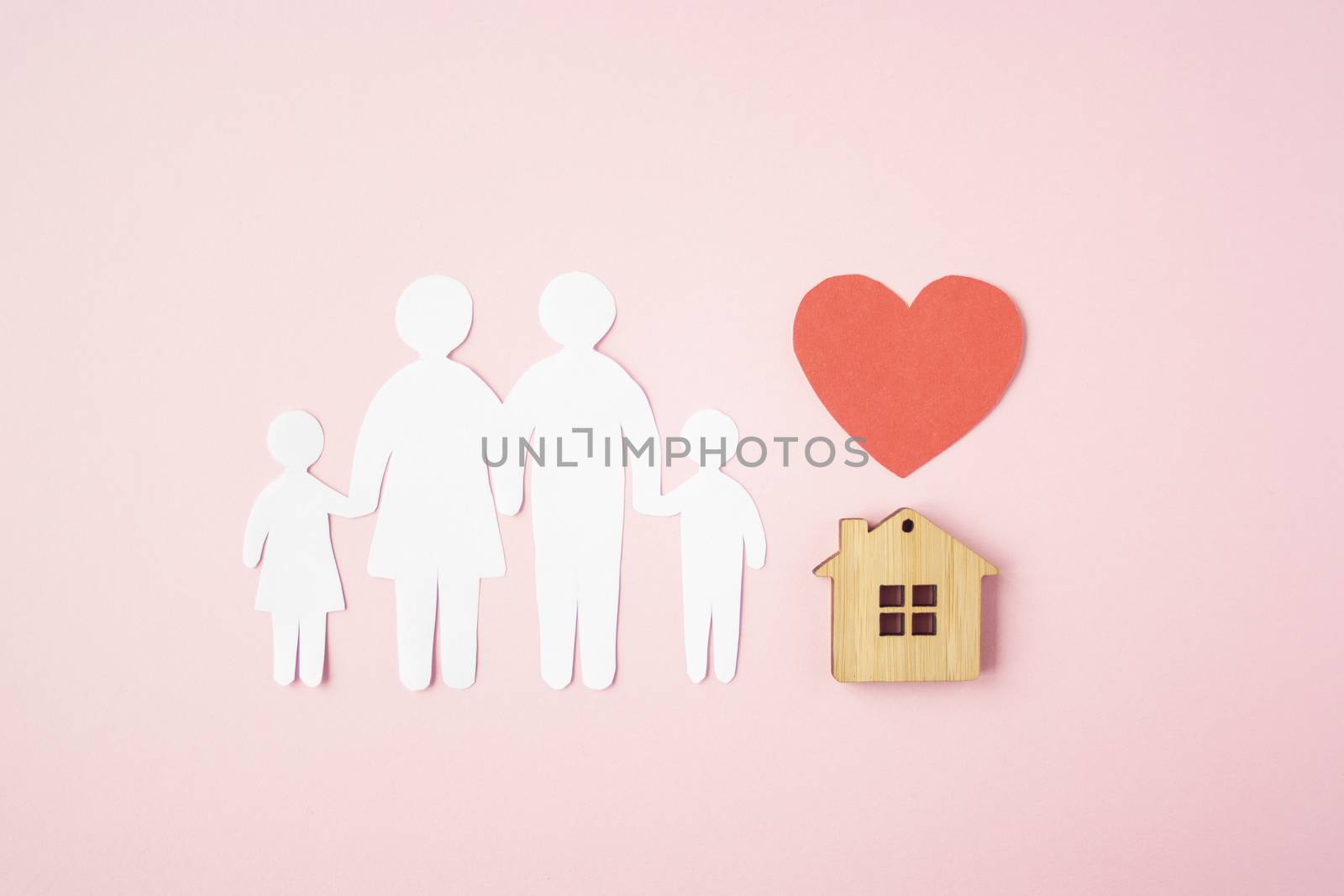 Happy paper family with house and red heart on pink background. Love and family union concept. 