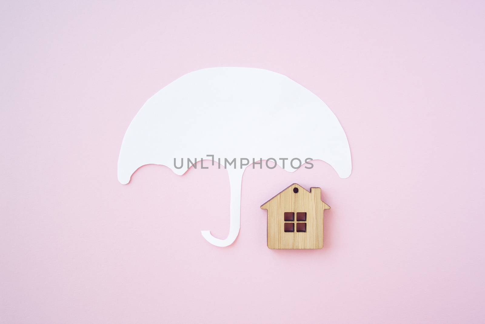 House insurance concept, house protection. Umbrella and wooden toy house for protect your house and property concept. 