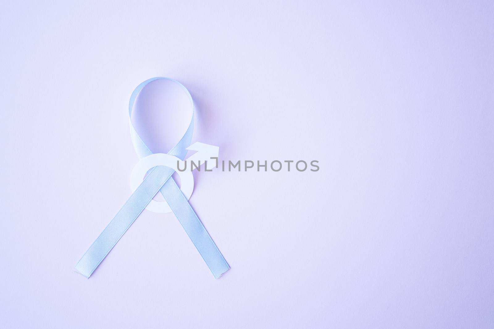 Prostate cancer awareness blue ribbon with white paper male sign mars arrow copy space on pink background. Men healthcare concept, men carcinoma symbol.