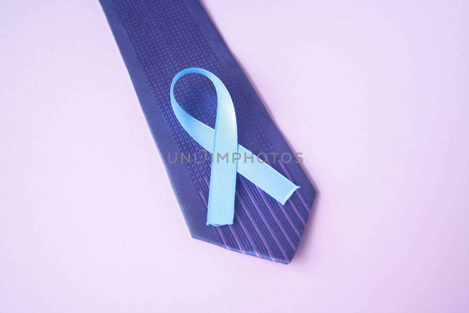 Prostate Cancer Awareness, light Blue Ribbon on blue men tie for support people living and illness. Men Healthcare and World cancer day concept. Men carcinoma health symbol
