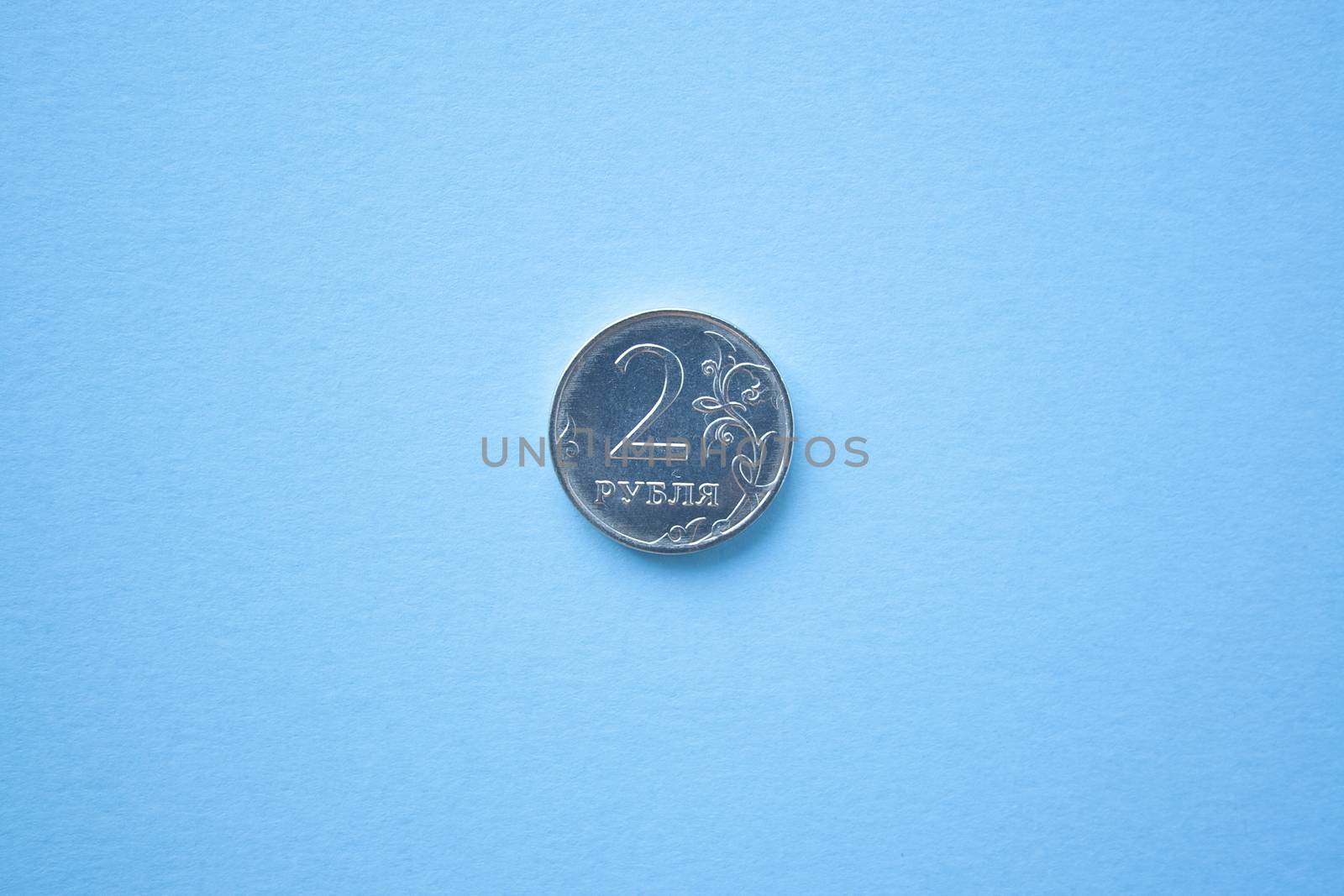 Coin two rouble on bright blue background. ruble depreciation. Rouble to dollar