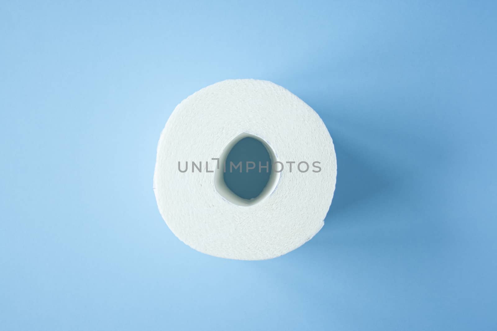 Toilet paper roll on a blue background top view. Toilet paper purchase due to kronavirus concept. Personal hygiene and stopping the spread of the virus. Cleanliness, Hygiene, Sterility